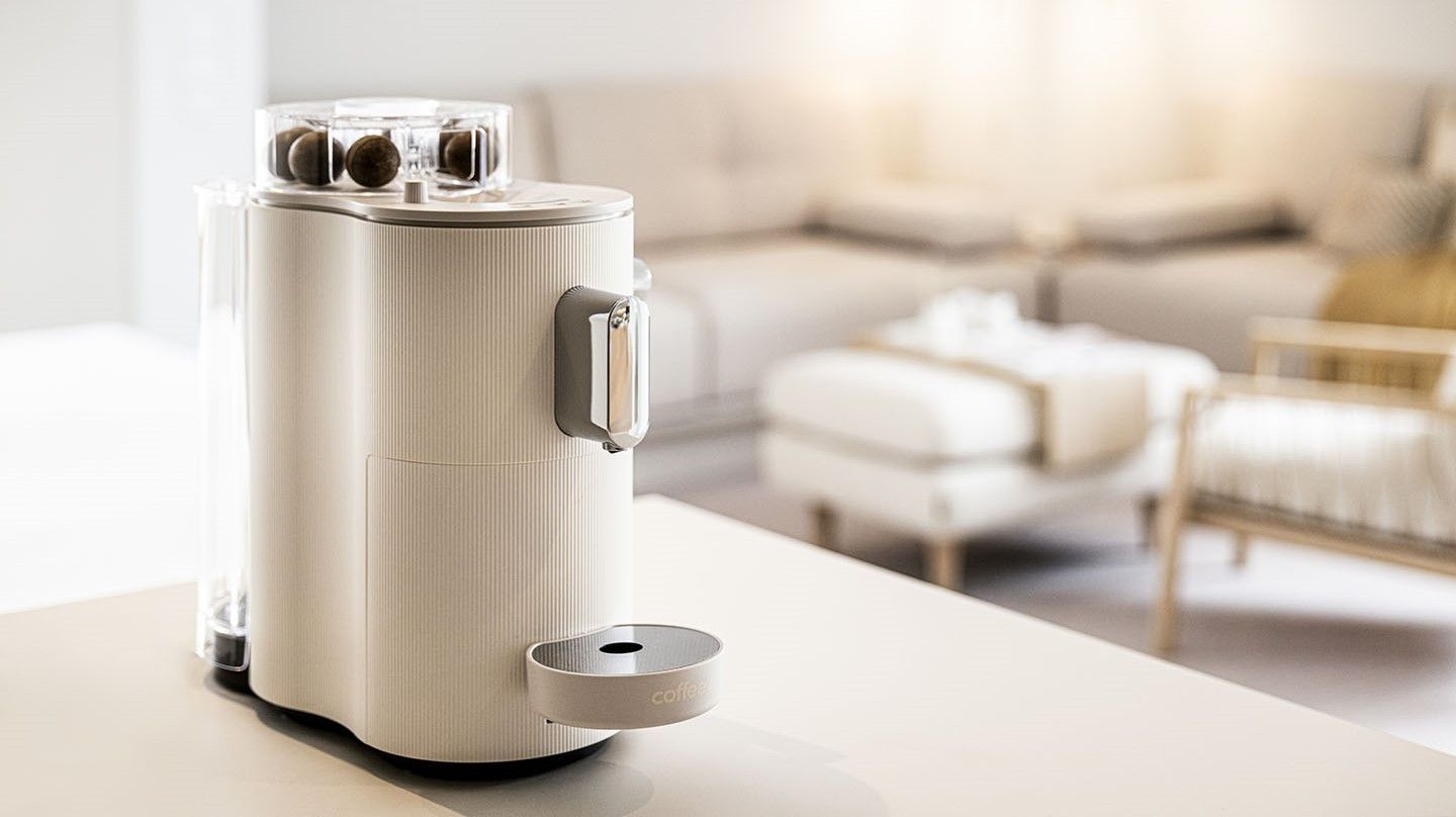 Eine weisse CoffeeB Kaffeemaschine steht auf einem Tisch