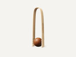 Eine CoffeeB Zange aus Bambusholz mit einem Coffee Ball.