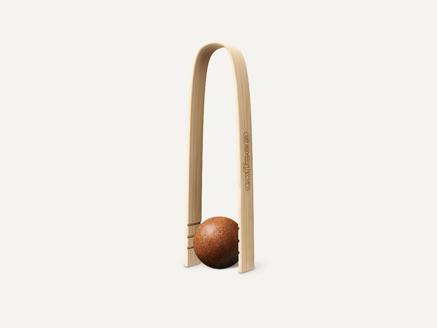 Eine CoffeeB Zange aus Bambusholz mit einem Coffee Ball.