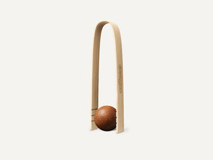 Eine CoffeeB Zange aus Bambusholz mit einem Coffee Ball.
